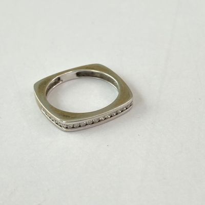 gros plan d'une bague en argent sur une surface blanche