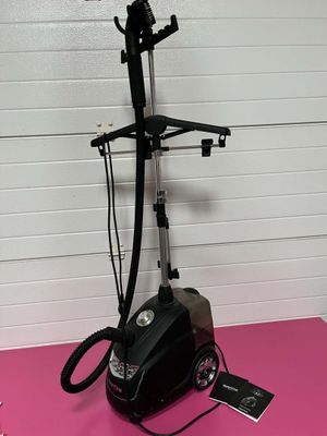 an image of a black and silver vacuum on a pink surface