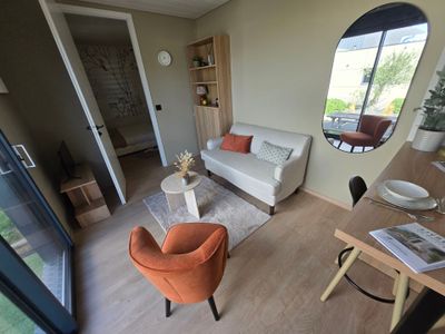 a living room with a couch, chair, table and a mirror