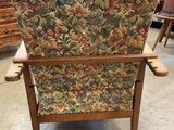 a chair with a floral upholstered back and arms