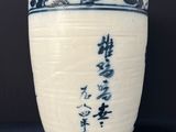 blue and white vase with oriental writing on it on a black surface