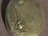 a gold locke with a picture of a bee on it