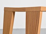 a close up of a wooden bench on a concrete floor