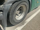 a close up of a truck ' s tire on the side of the road