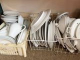 de nombreuses assiettes et casseroles dans un panier posé par terre