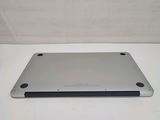 the back of a silver laptop computer sitting on top of a white table