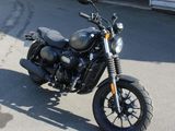 a black motorcycle parked in front of a garage
