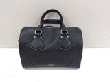 a black handbag sitting on top of a white table