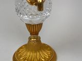 a glass vase with a gold decoration on top of it