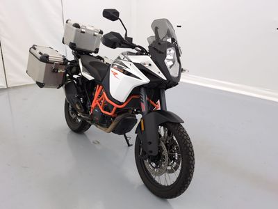 une moto blanche et orange garée dans une pièce blanche