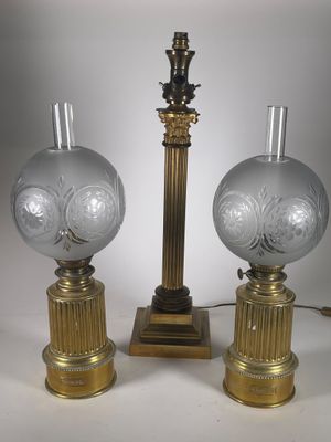 une paire de lampes en verre avec des pieds dorés et un pied doré