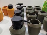 many different colored vases sitting on a white table