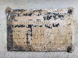 an old sign on the side of a building that has been rusted