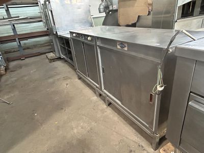 une cuisine avec de nombreux plans de travail en inox
