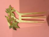 une fourchette sur laquelle est posée une plante, posée sur une surface rose