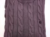 Le pull est violet et présente un motif torsadé.