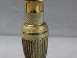 a small gold vase on a stand on a table