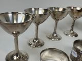 several silver cups and spoons are lined up on a table