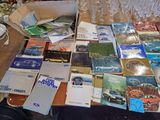 a lot of books on a table with a bottle of water