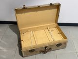 une vieille valise posée par terre dans une pièce