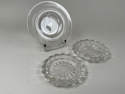 three glass plates and a clock sitting on a table