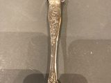 a silver spoon on a table with a shadow of a person