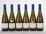 six bottles of wine are lined up in a row on a white surface