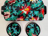 un plateau noir orné d'un motif floral et deux dessous de verre assortis
