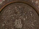 a brown plate with designs on it on a table