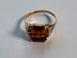 an image of a gold ring with a brown stone on it