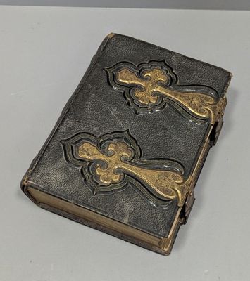 un livre orné d'une croix, posé sur une table