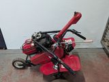 a small red machine that is sitting on the floor
