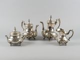 three pieces of silver tea and coffee set on a table