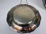 a silver plate hanging from a hook on a table