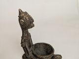 bronze statue of a cat with a bowl in its mouth