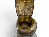 a glass toilet with a gold lid on a white surface
