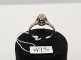 une bague sertie d'un diamant, posée sur un présentoir noir