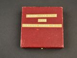 an old red book sitting on top of a black table