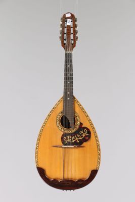 a guitar hanging from a string on a wall
