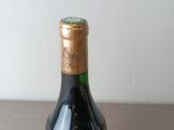 a bottle of wine sitting on top of a table next to a bottle of wine