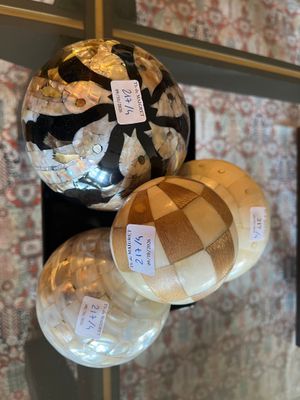 trois boules en verre accrochées à un mur, sur lesquelles sont collés des autocollants