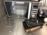 a microwave sitting on top of a counter next to a tray of food