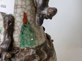 a vase with a bird on it sitting on a table