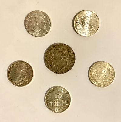 six different coins are arranged in a circle on a white surface