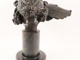 bronze head of a woman with wings on a marble base