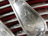 a close up of a silver spoon and fork on a red cloth