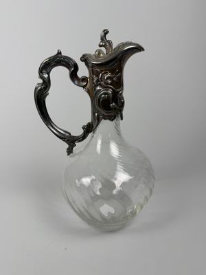 un pichet ancien en verre plaqué argent sur fond blanc