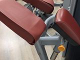 many machines in the gym with red seats on them