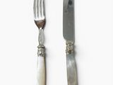 two forks and a knife on a white surface