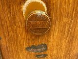 a close up of a wooden cabinet with a metal knob